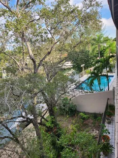 an aerial view of residential house with outdoor space and trees all around