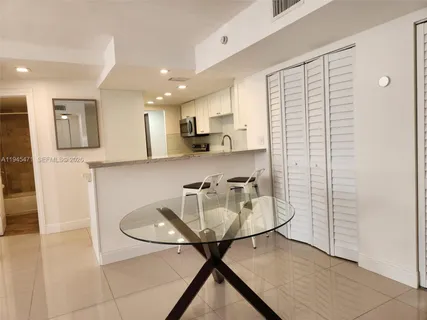 a kitchen with stainless steel appliances granite countertop a sink and a refrigerator