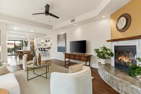a living room with furniture a fireplace and a flat screen tv