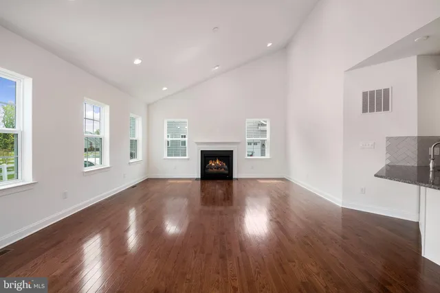 a view of kitchen with refrigerator and wooden floor