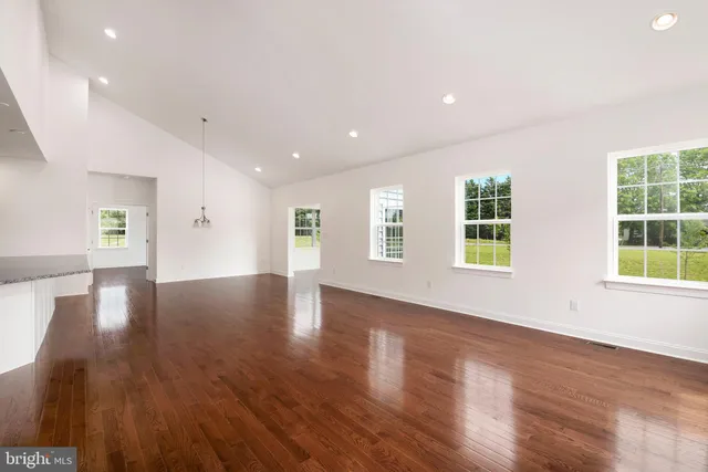 a view of empty room with wooden floor
