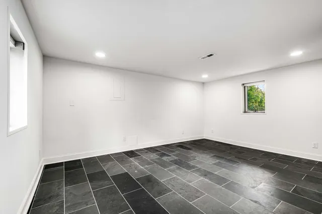 an empty room with white wall and a window