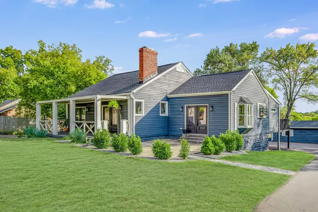 a view of a house with a yard and potted plants