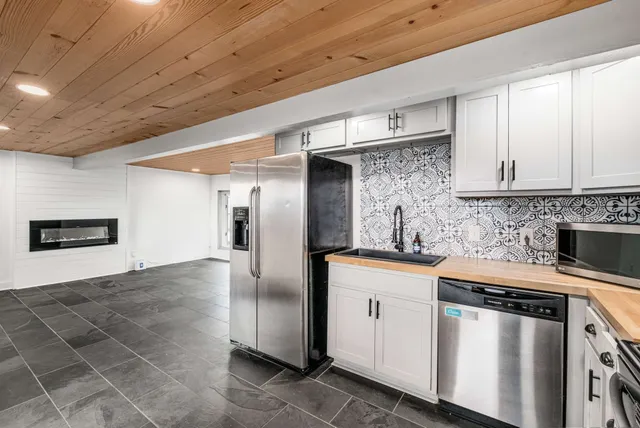 a kitchen with stainless steel appliances granite countertop a refrigerator and a stove