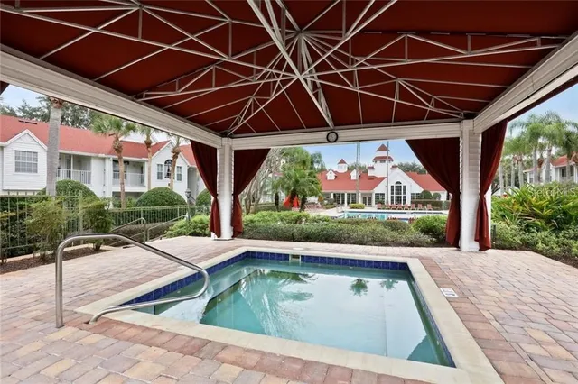 a view of a livingroom with wooden floor a ceiling fan and windows
