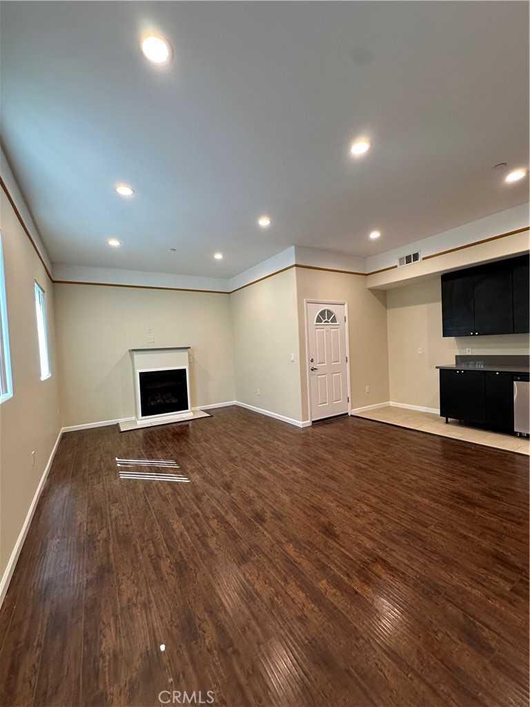 14233 Tiara Street, Unit 3 Sherman Oaks, CA 91401 - Photo 6 of 20 a view of empty room with wooden floor and fireplace