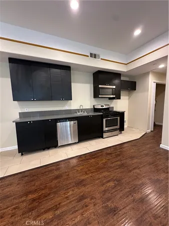 a view of an empty room with wooden floor and a fireplace