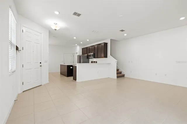 a view of a kitchen with stairs and an entryway