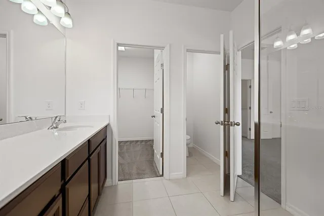 a bathroom with a double vanity sink a large mirror and a shower