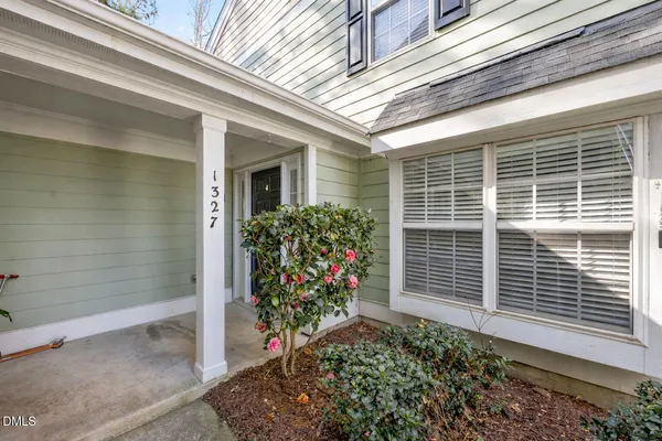a view of a brick house with a yard and large tree