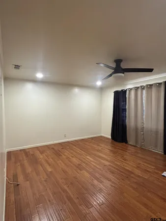 a view of an empty room with wooden floor