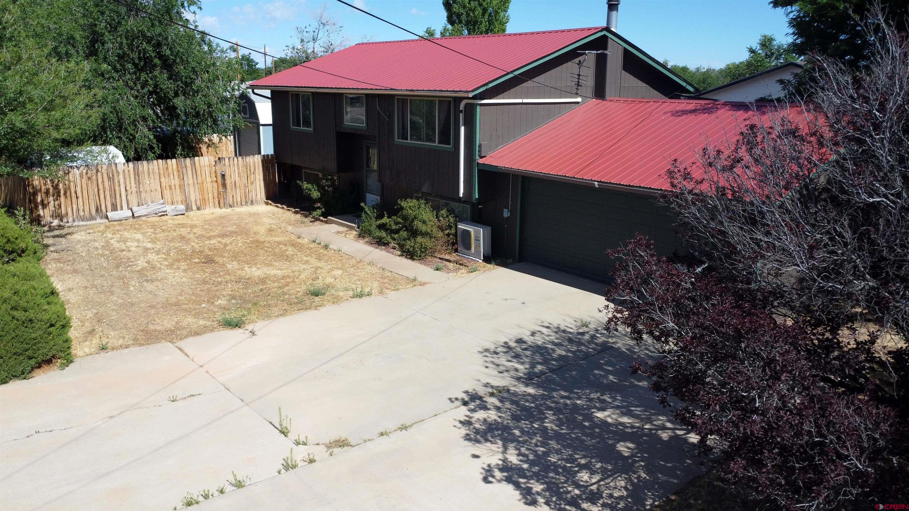 1328 Jackson Street Cortez, CO 81321 - Photo 5 of 37 a front view of a house with yard and covered with trees