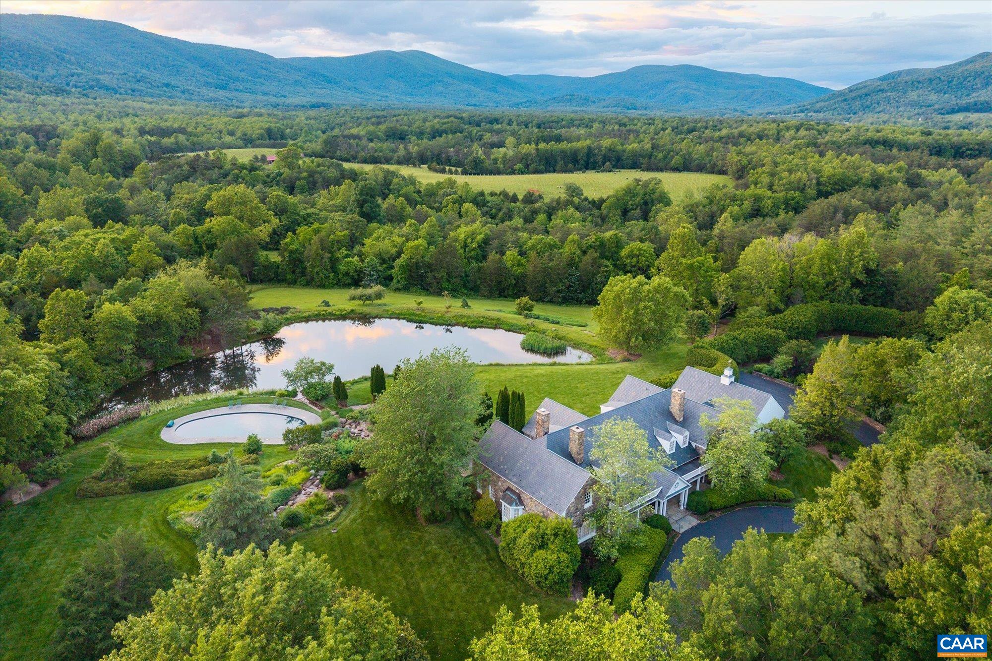 an aerial view of green landscape with trees houses and mountain view