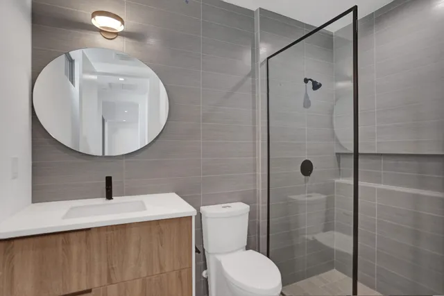 a bathroom with a sink a toilet and shower