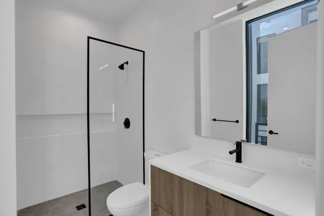 a bathroom with a sink a toilet and shower