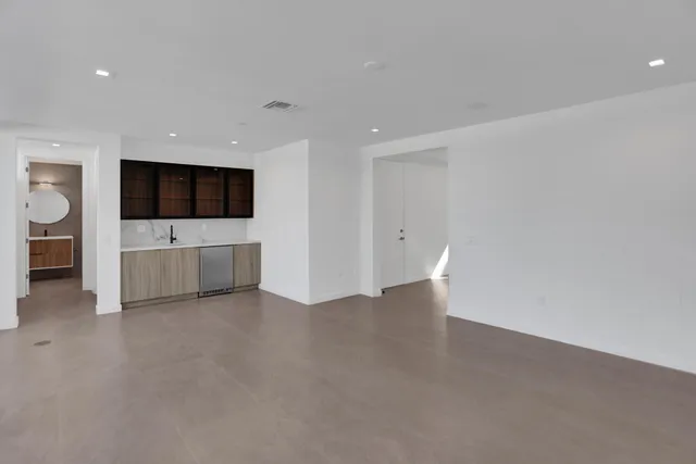 a view of an empty room with a tv and a kitchen