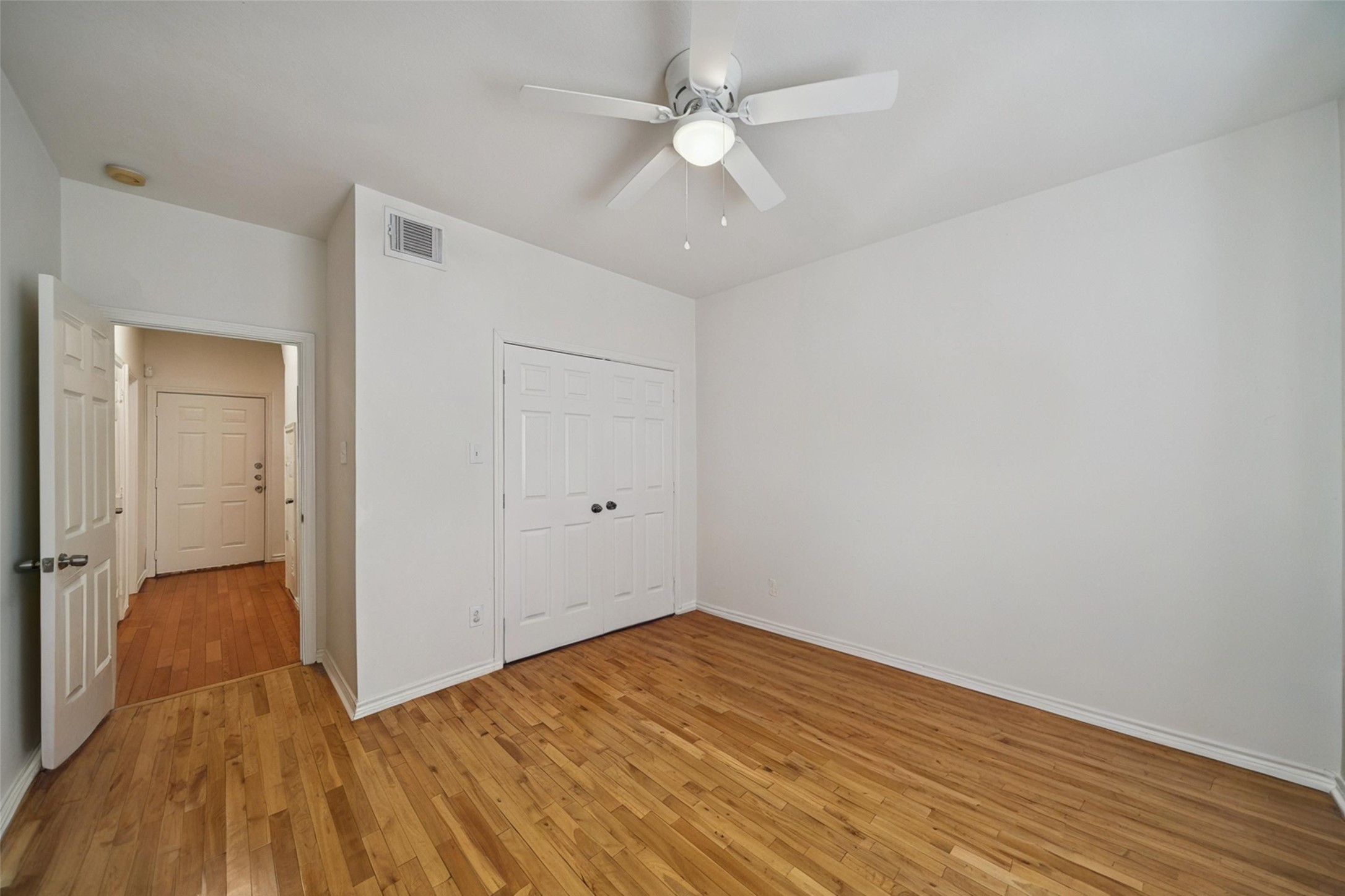 5531 Cornish Street Houston, TX 77007 - Photo 5 of 32 an empty room with wooden floor and a ceiling fan