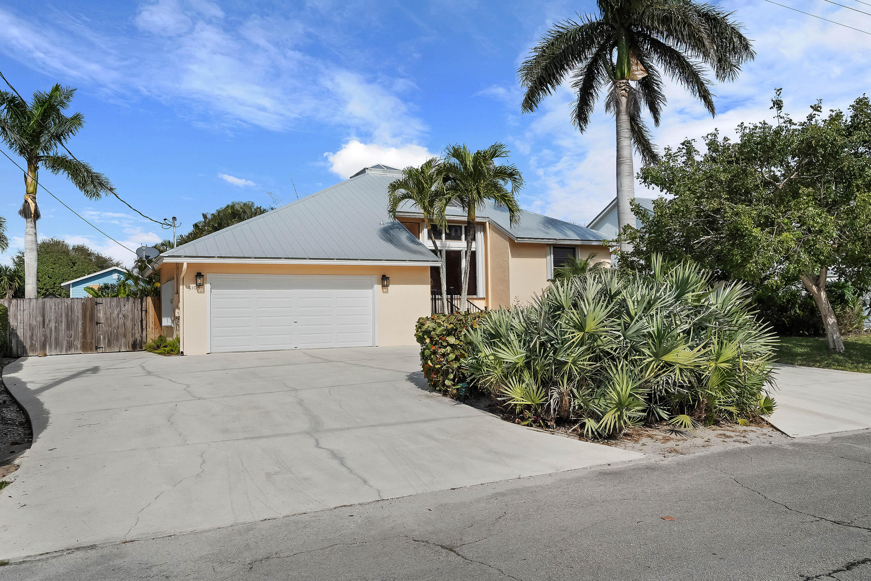 5105 Southeast Matousek Street Stuart, FL 34997 - Photo 3 of 48 a front view of a house with a yard and garage