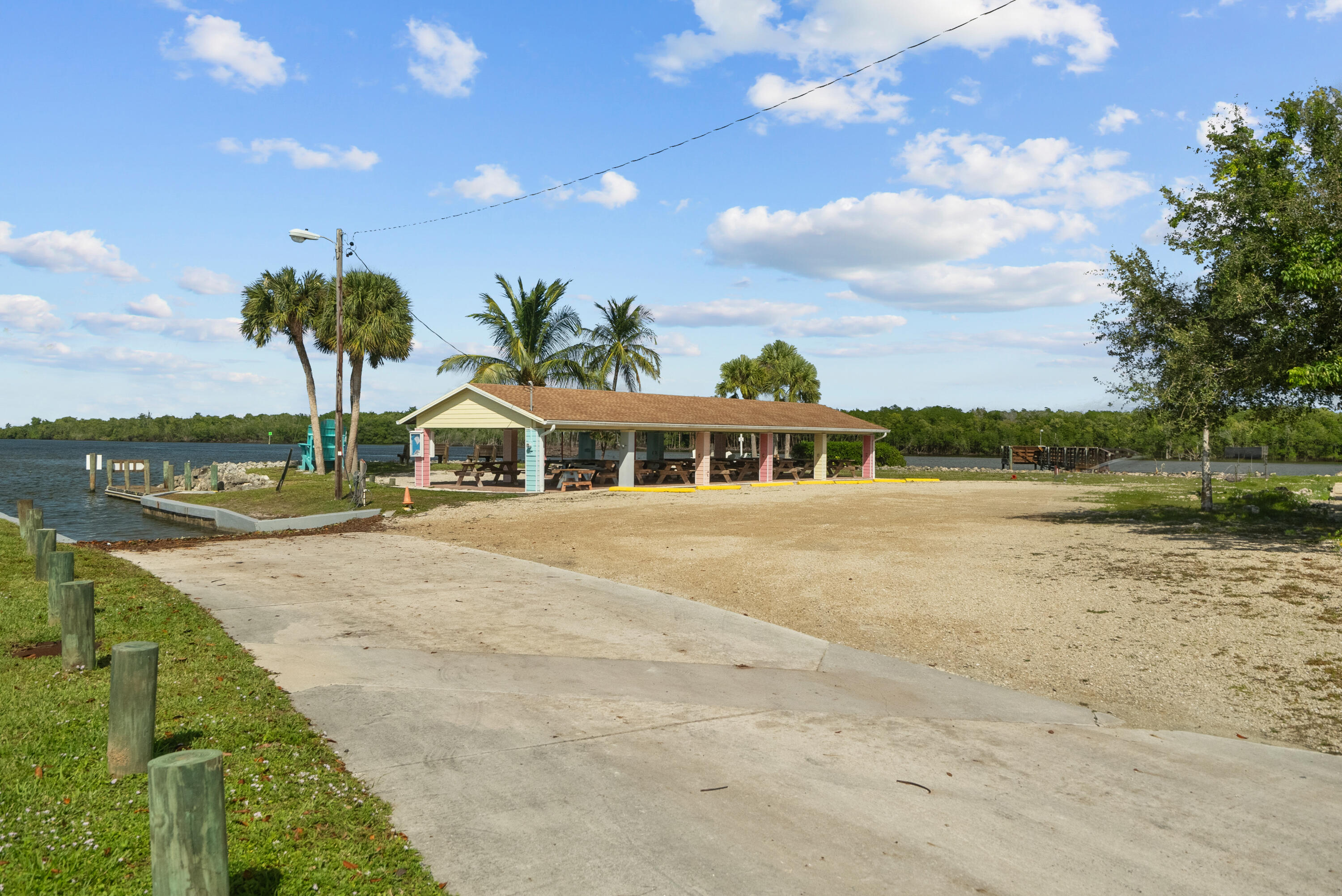 5105 Southeast Matousek Street Stuart, FL 34997 - Photo 44 of 48 a front view of a house with a yard and lake view