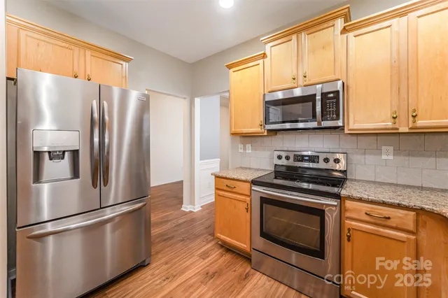 a kitchen with stainless steel appliances granite countertop a refrigerator stove and microwave