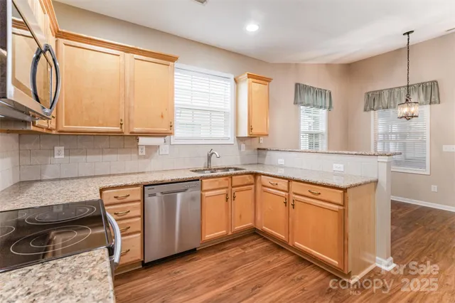 a kitchen with stainless steel appliances granite countertop wooden cabinets a sink and a stove
