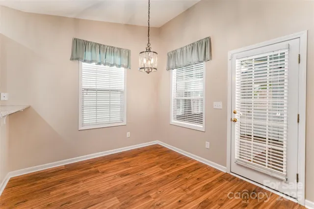 a view of a livingroom with wooden floor and windows