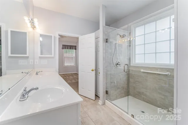 a bathroom with a shower sink and mirror