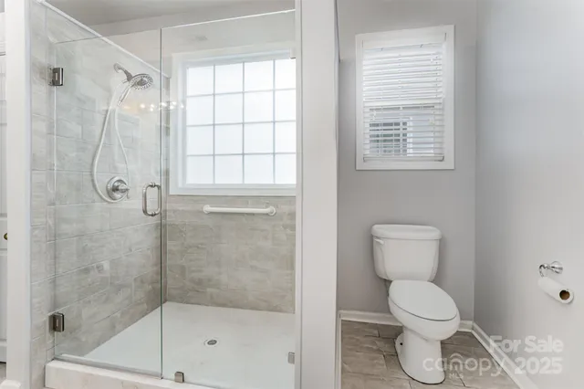 a bathroom with a toilet and a shower