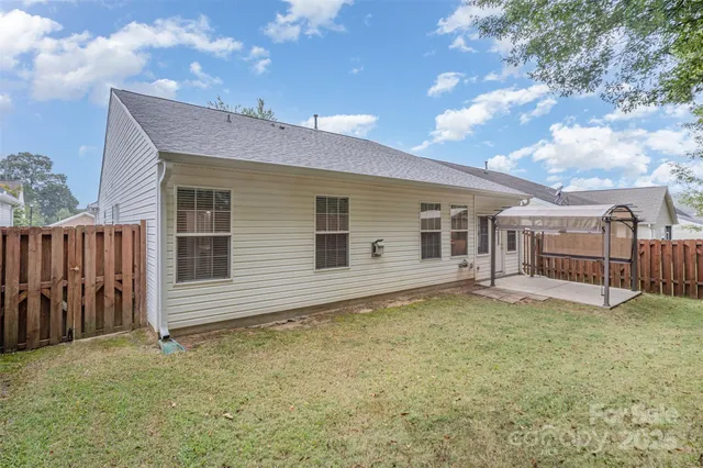 a view of a house with backyard and sitting area