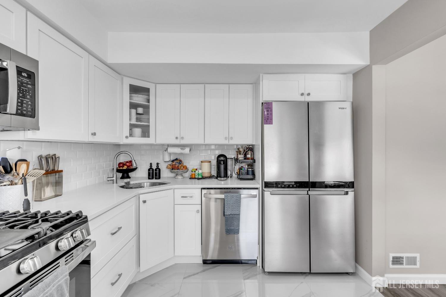 1933 Raspberry Court Edison, NJ 08817 - Photo 12 of 30 a kitchen with white cabinets and white appliances