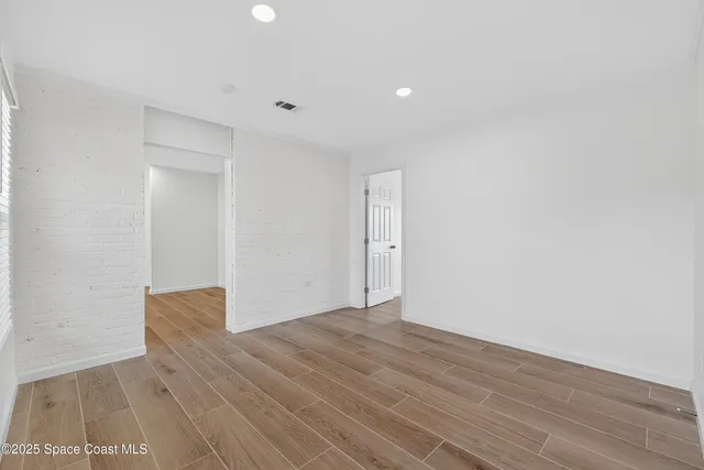 an empty room with a window and a ceiling fan