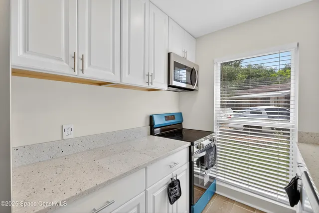 a view of a kitchen with fridge and wooden floor