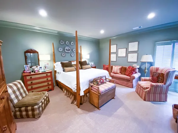 a spacious bedroom with a bed and wooden floor