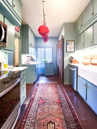 a kitchen that has a microwave a stove and a wooden floor