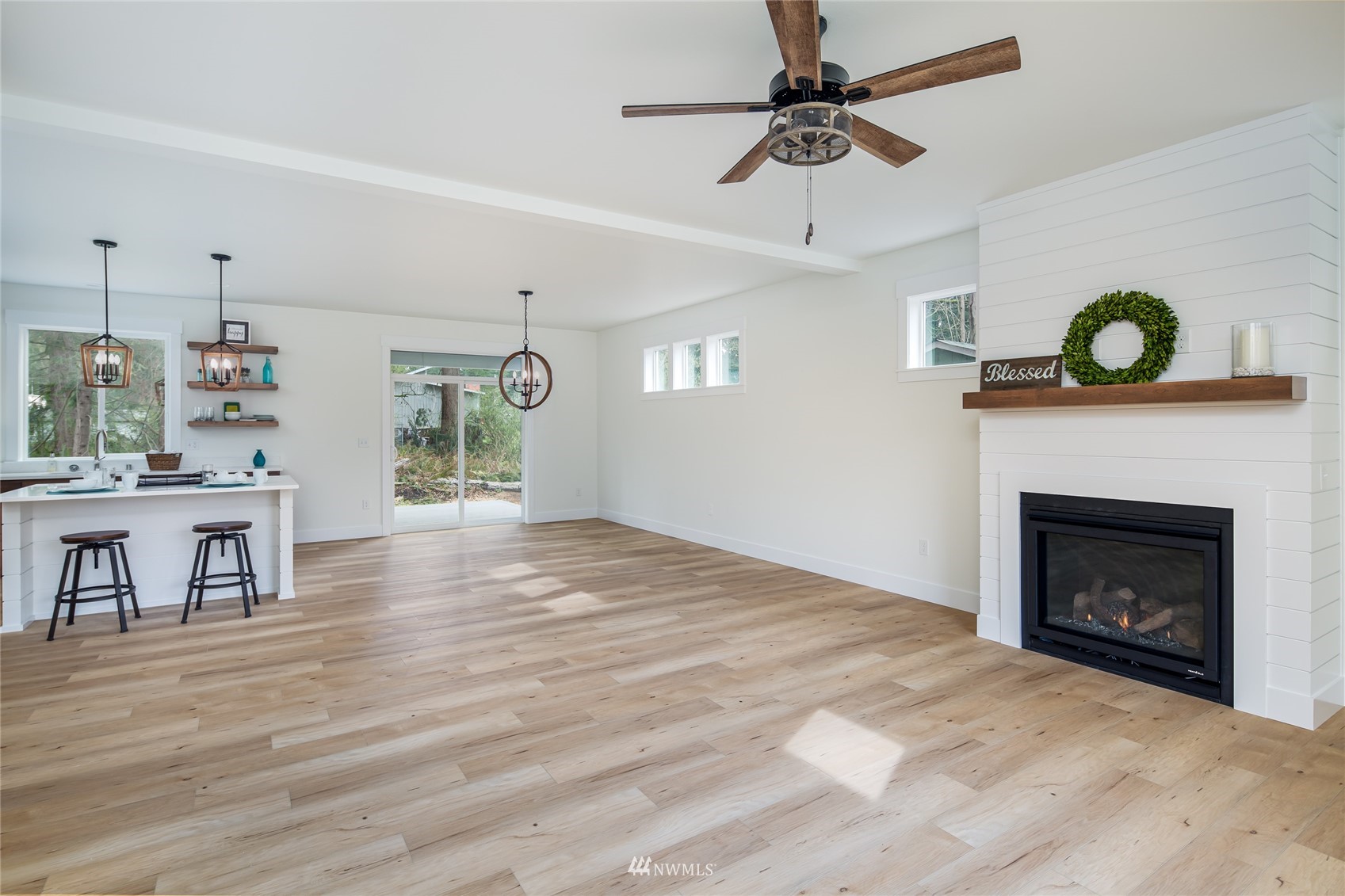 2284 South 19th Street Mount Vernon, WA 98274 - Photo 19 of 29 a view of a livingroom with a fireplace a chandelier fan and wooden floor