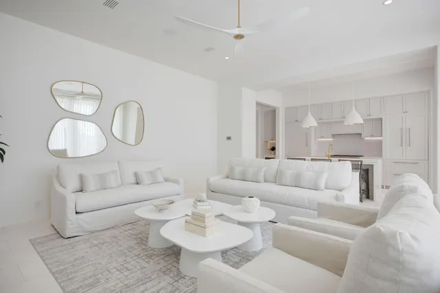 a living room with furniture a mirror and wooden floor