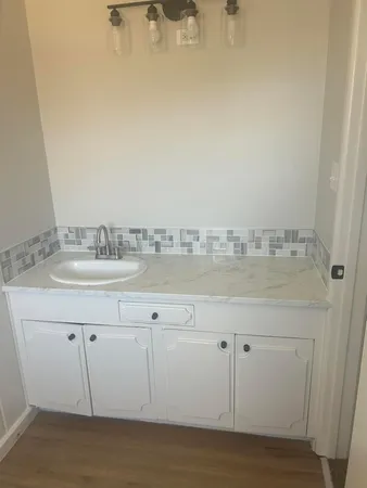 a bathroom with a sink vanity granite and a mirror