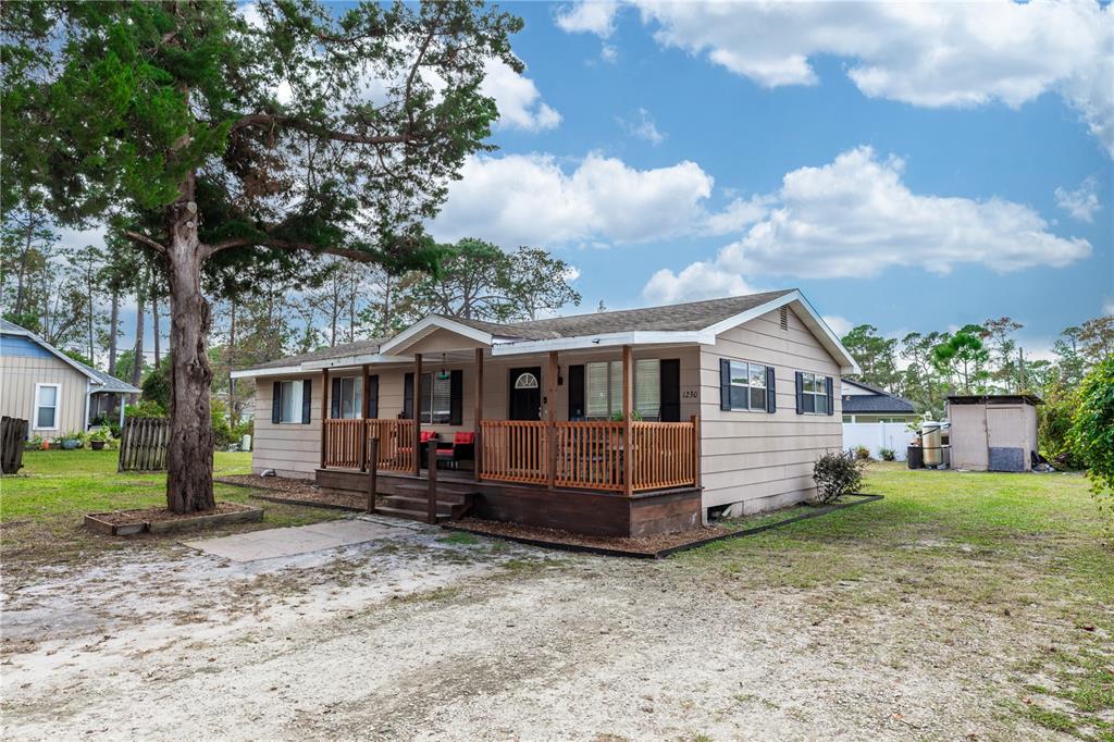 1230 8th Avenue DeLand, FL 32724 - Photo 2 of 25 a front view of a house with a yard and trees