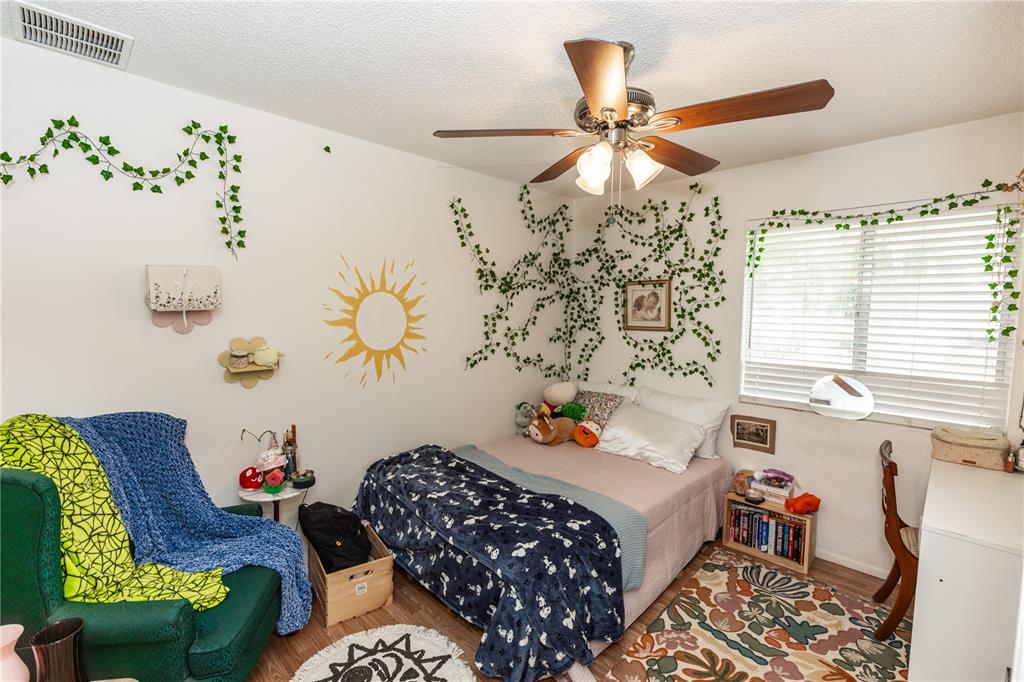 1230 8th Avenue DeLand, FL 32724 - Photo 22 of 25 a bedroom with a bed and a chandelier