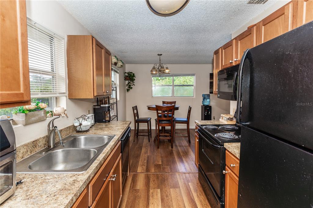 1230 8th Avenue DeLand, FL 32724 - Photo 8 of 25 a kitchen with granite countertop a stove a sink a dining table and chairs