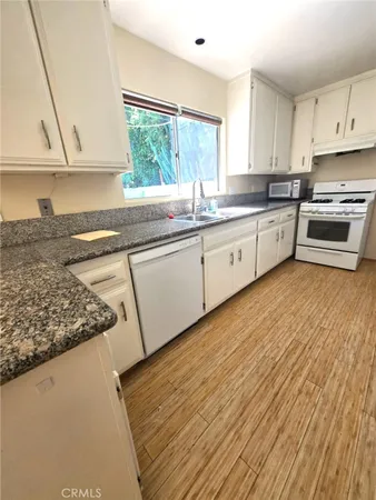a kitchen with stainless steel appliances granite countertop a sink a stove and cabinets