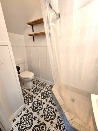a bathroom with a toilet and a shower