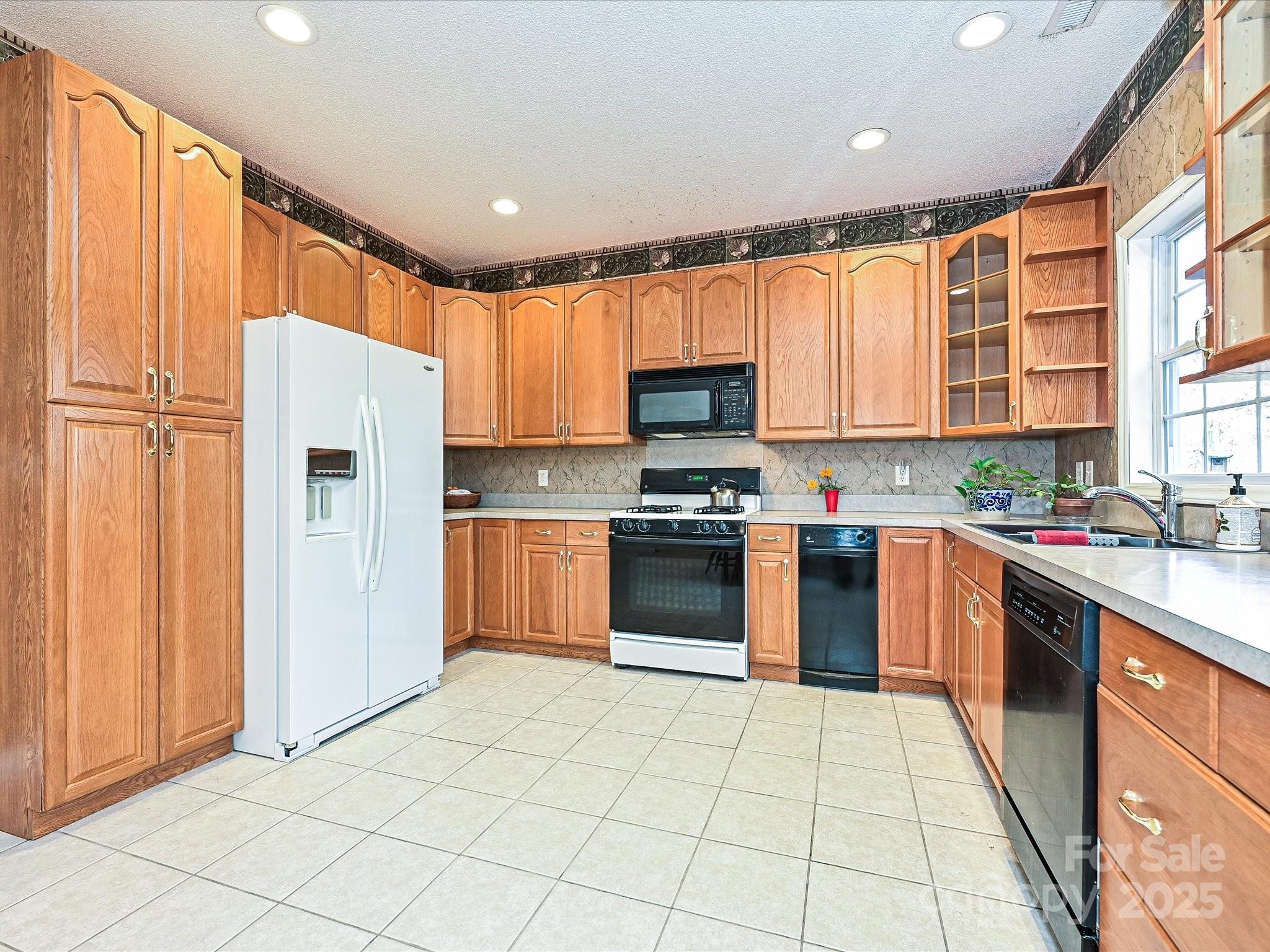 25040 Timberlake Drive Tega Cay, SC 29708 - Photo 12 of 40 a kitchen with stainless steel appliances granite countertop a refrigerator sink and cabinets