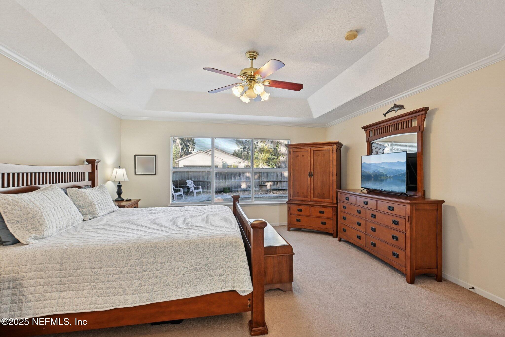 1862 Sentry Oak Court Fleming Island, FL 32003 - Photo 12 of 83 a bedroom with a bed and furniture with a flat tv screen