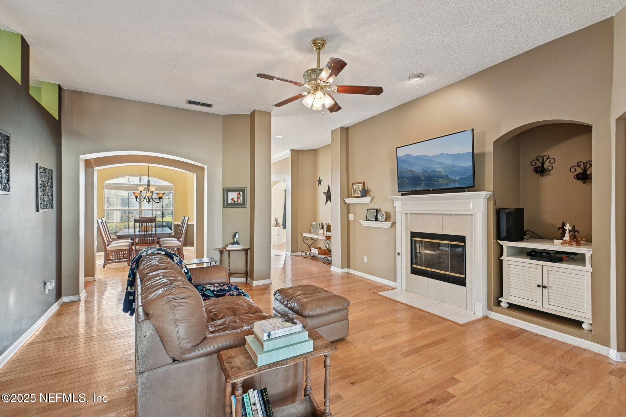 1862 Sentry Oak Court Fleming Island, FL 32003 - Photo 32 of 83 a living room with furniture a fireplace and a flat screen tv