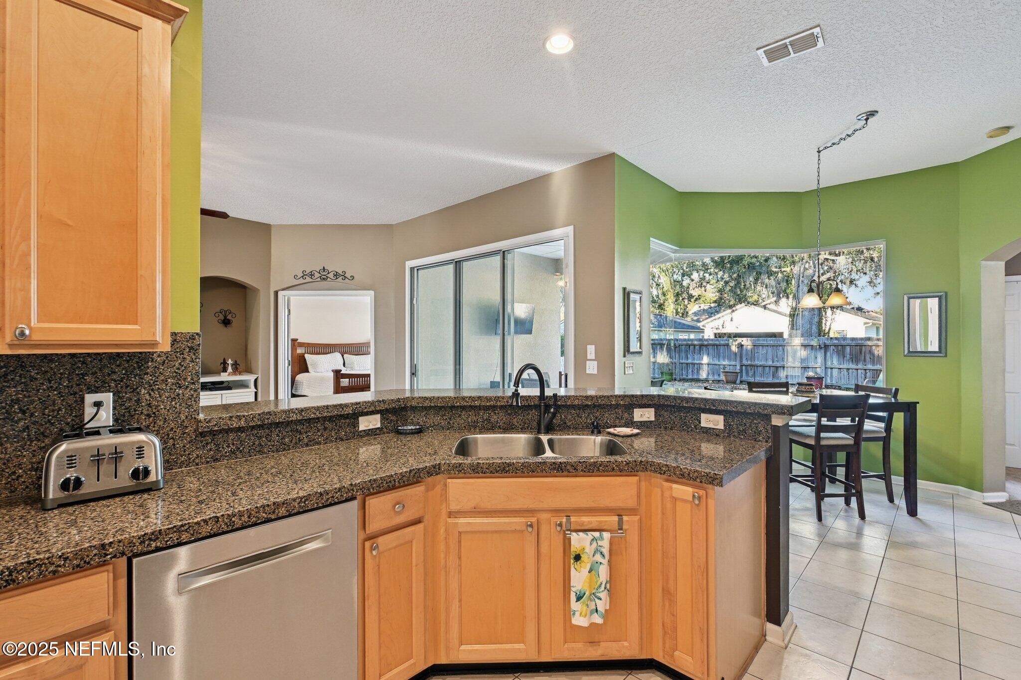 1862 Sentry Oak Court Fleming Island, FL 32003 - Photo 34 of 83 a kitchen with stainless steel appliances granite countertop a sink and cabinets