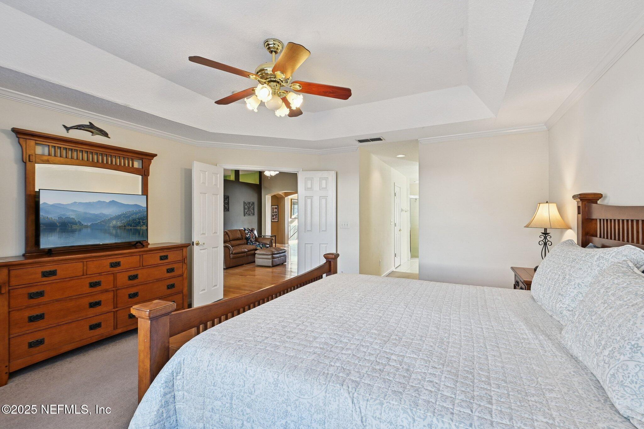 1862 Sentry Oak Court Fleming Island, FL 32003 - Photo 40 of 83 a bedroom with a bed and a flat tv screen on dresser