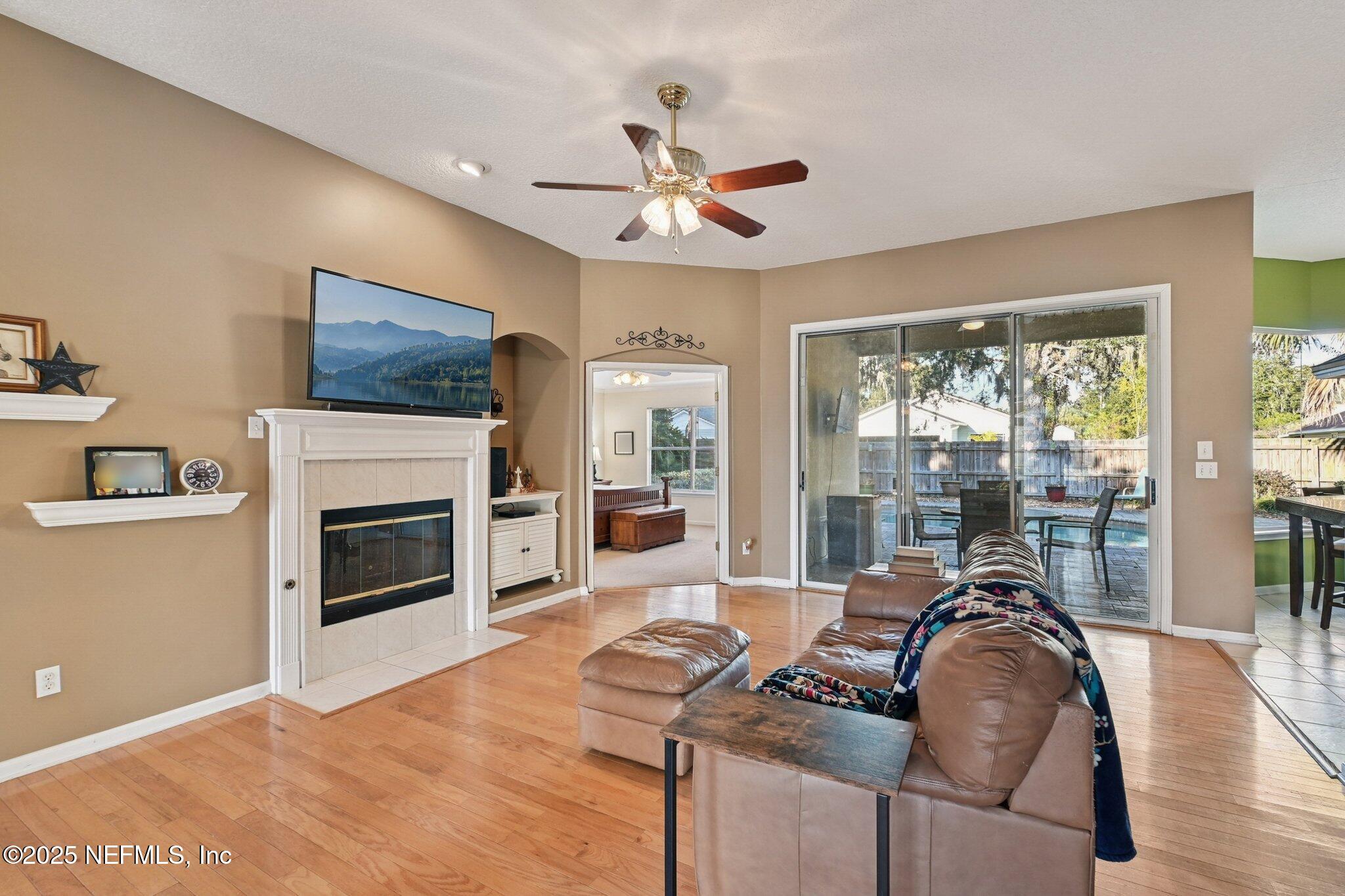 1862 Sentry Oak Court Fleming Island, FL 32003 - Photo 6 of 83 a living room with furniture a fireplace and a flat screen tv