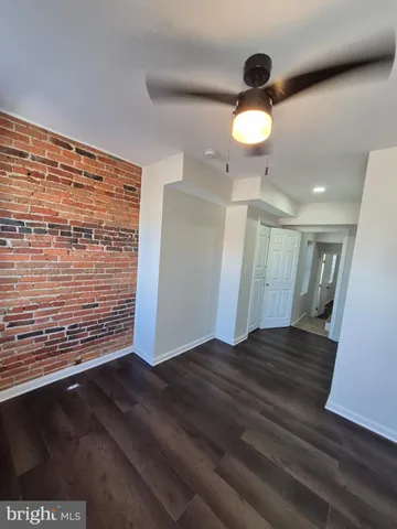 a view of an empty room with wooden floor and a large window