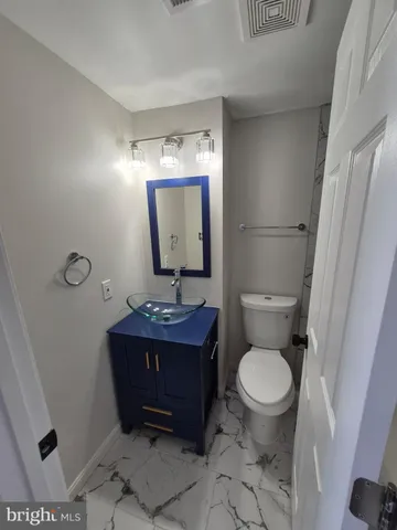 a bathroom with a toilet a sink and mirror